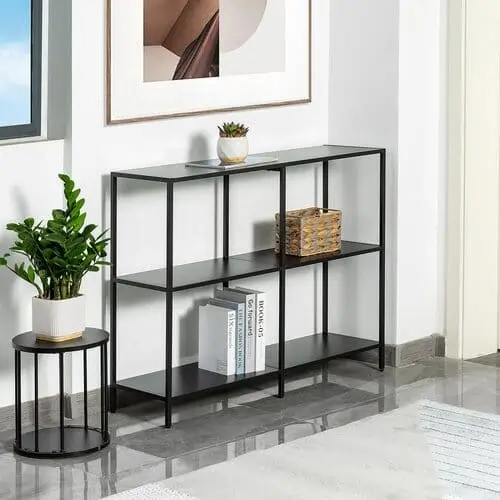 Modern black entryway table with minimalist decor, featuring a stylish lamp, decorative bowl, and a cozy rug. This chic setup adds functional and fashionable charm to any apartment entryway.