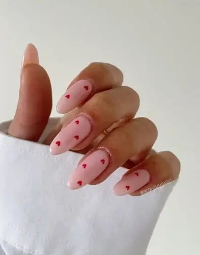 Classic dainty hearts Valentine’s nails featuring soft pink polish with tiny red heart accents for a romantic and elegant look perfect for Valentine’s Day.