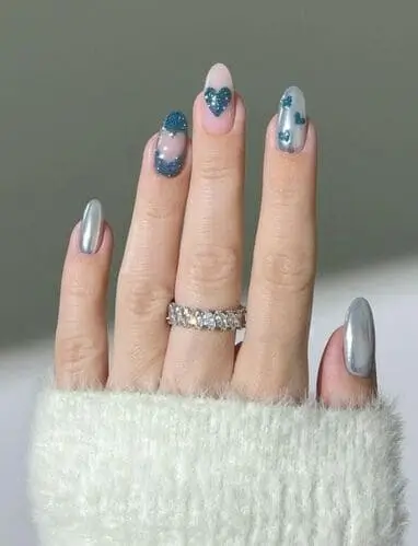 Icy blue Valentine’s nails with dreamy blue chrome accents and glittery hearts for a frosty and romantic manicure.