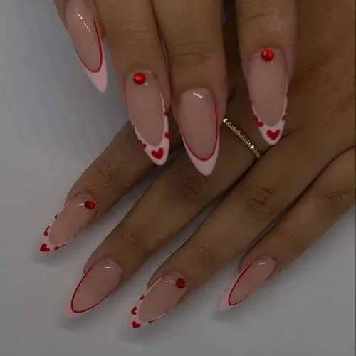 Valentine’s Slim Pink French Tip Nails with dainty hearts and red crystals for a minimalist yet romantic manicure that shines.