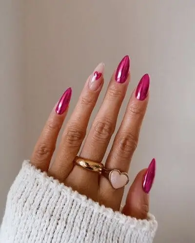 Pink chrome nails with a neutral accent nail featuring a small pink chrome heart for a sleek and stylish Valentine's Day design. A trendy and romantic look.