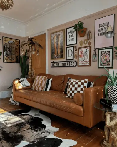 Retro maximalist living room with brown leather retro couch, checkered print and retro throw pillows, and vintage signs and movie poster collection on wall