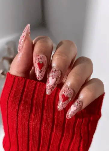 Valentine's nails with chunky glitter and red and pink hearts for a look that's sweeter than a cupcake