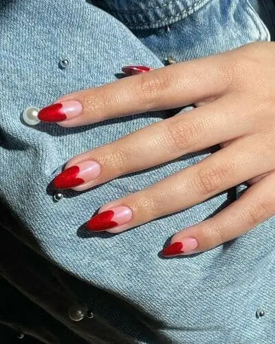 Taylor Swift Valentine's Day nails with heart-shaped French tips inspired by the Lover era, featuring red heart tips for a romantic and whimsical design.