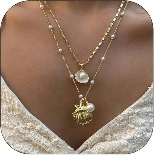 Layered beachy seashell necklaces with delicate gold chains and small seashell pendants, perfect for a coastal cowgirl or beach-inspired aesthetic.