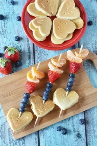 Skewer heart-shaped pancakes with fresh fruits for a cute Valentine's breakfast idea!